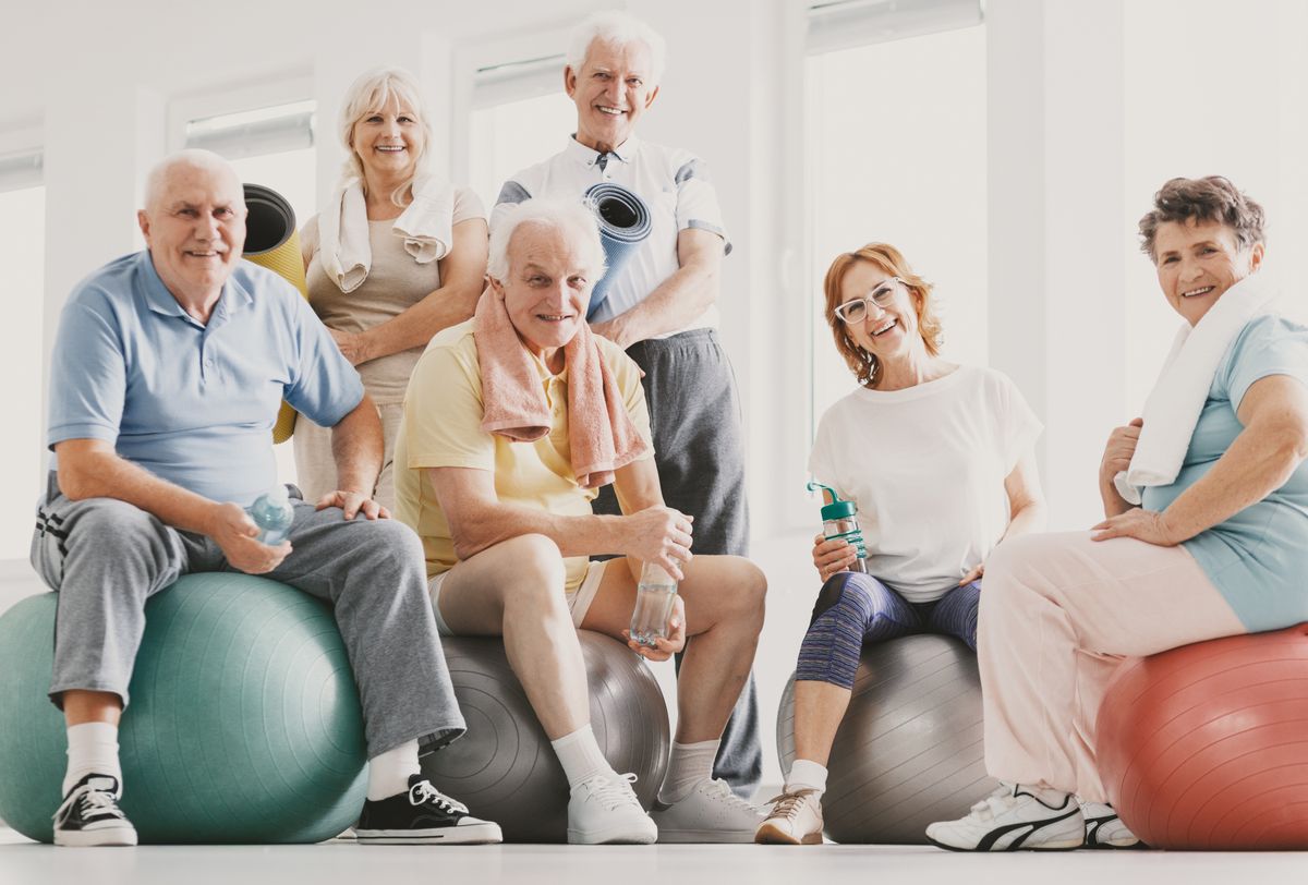 Group of smiling active elderly people practicing yoga.